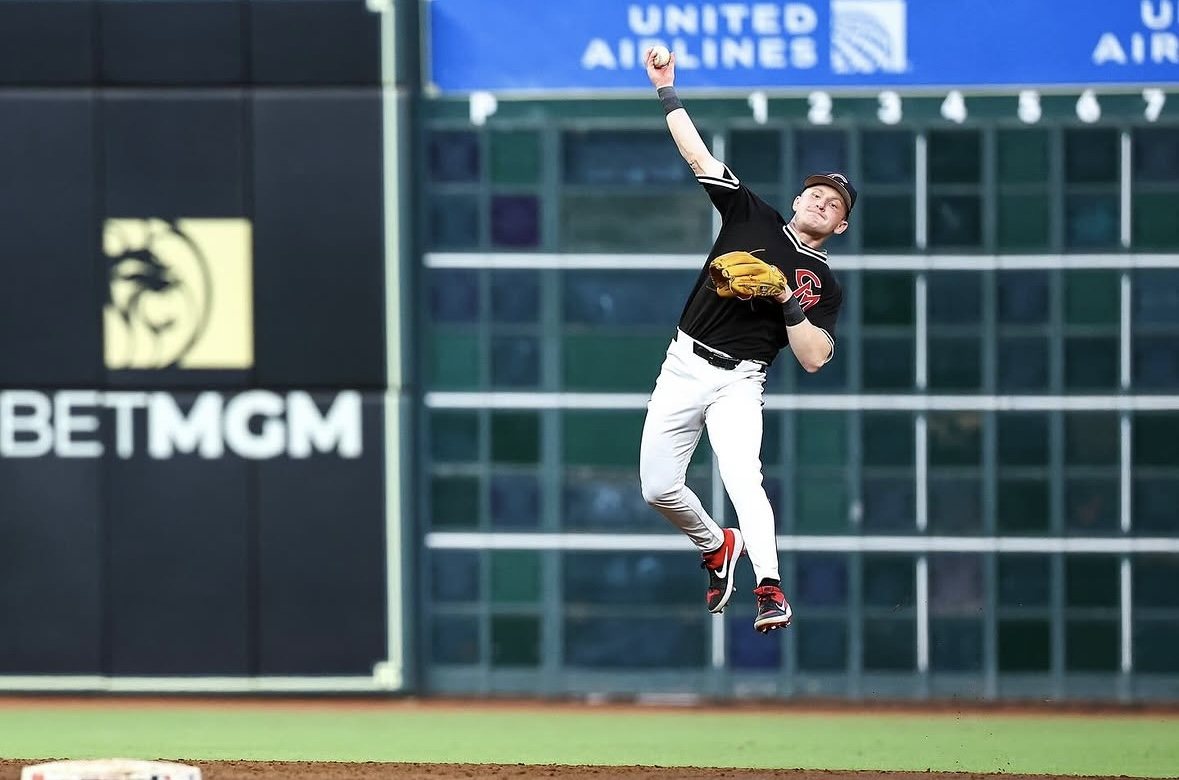 Mules infielder making a jump throw in front of the left-field scoreboard